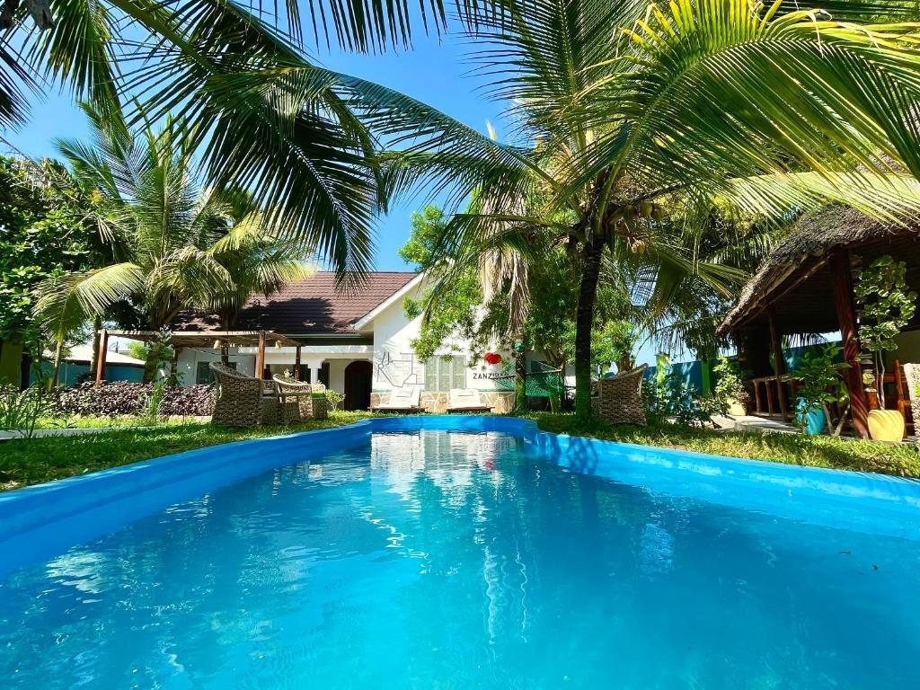 南威Green's Nungwi的棕榈树屋前的游泳池