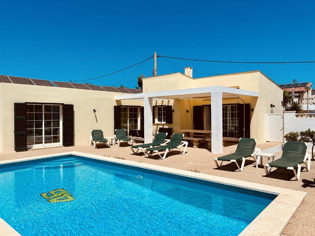 卡拉恩波特Villa Jordi - Cala en Porter的一个带椅子的游泳池以及一座房子