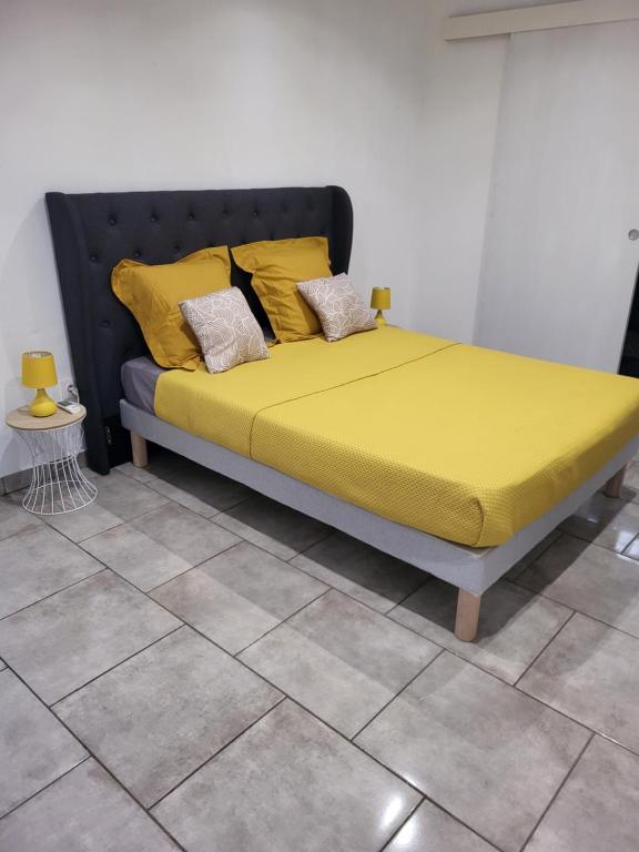 BourdaRésidence Ariane的一张带黄色床单和枕头的床