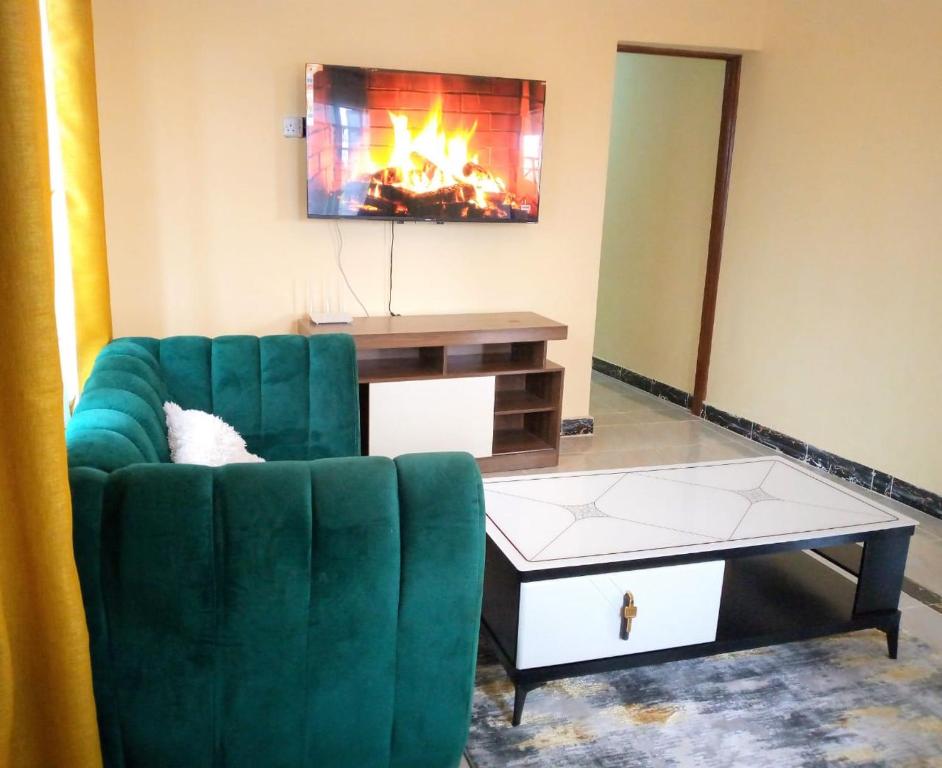 Fine Living - Busia的客厅配有绿色沙发和茶几