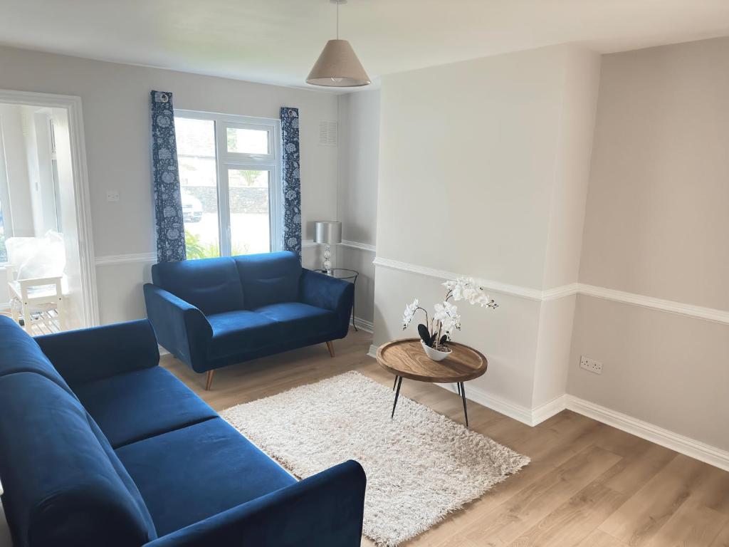 布莱辛顿Tully's Home, Tulfarris Village, Wicklow的客厅配有蓝色的沙发和桌子