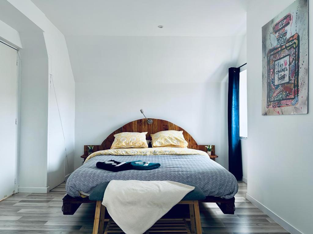 蒙塔日La Perle的一间卧室配有一张带木制床头板的床