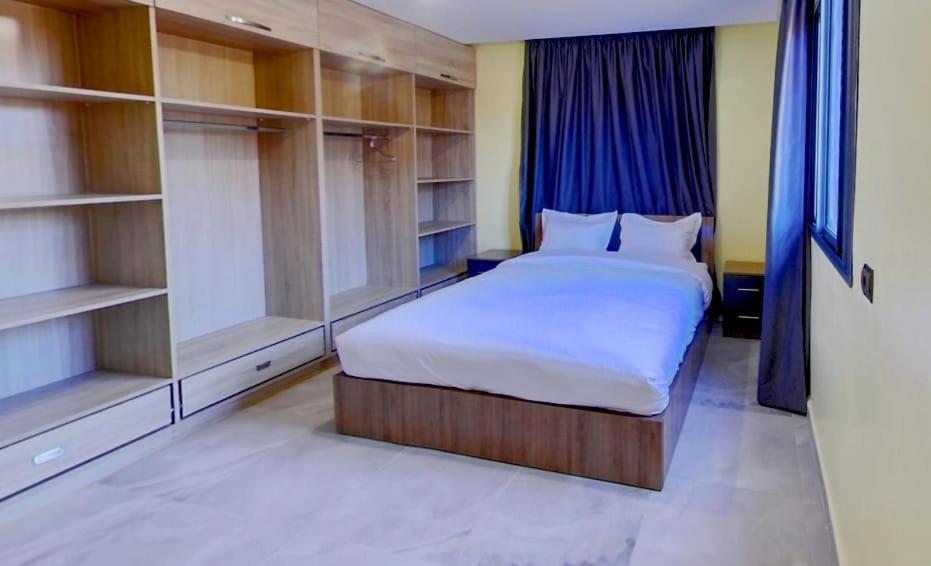 达赫拉KHALIJ HOSPITALITE的卧室配有白色的大床和架子