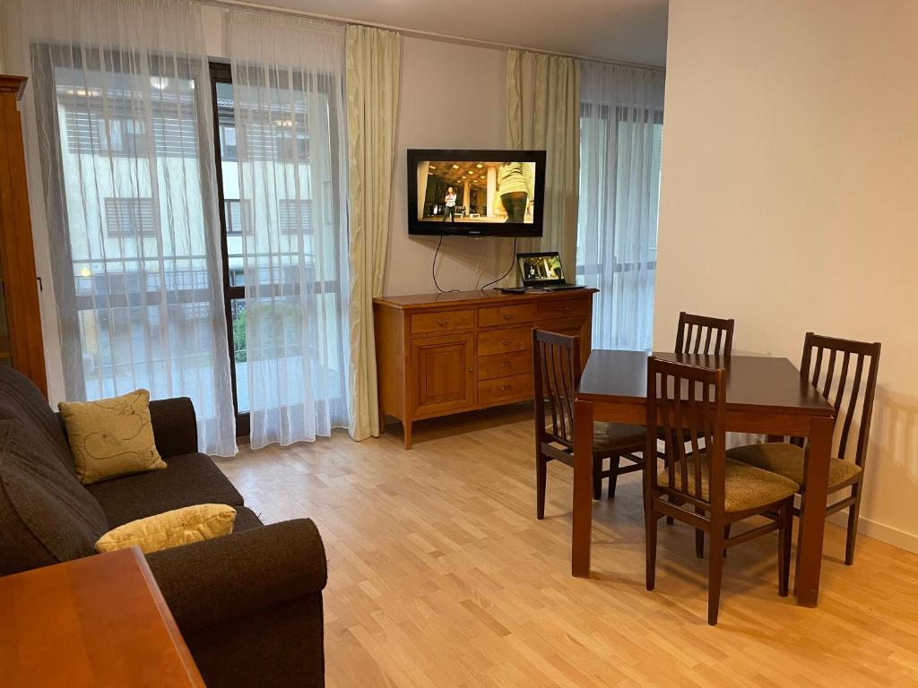 格但斯克Apartament Dominikański Oliwa的客厅配有桌椅和电视。
