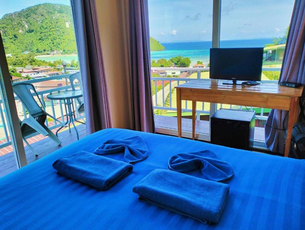 皮皮岛Blue View House Phi Phi的一间享有海景的卧室,配有一张蓝色的床