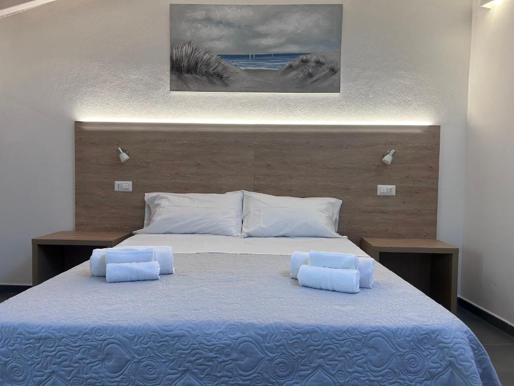 托尔托利Longevity Hotel的一间卧室配有一张大床和两个枕头