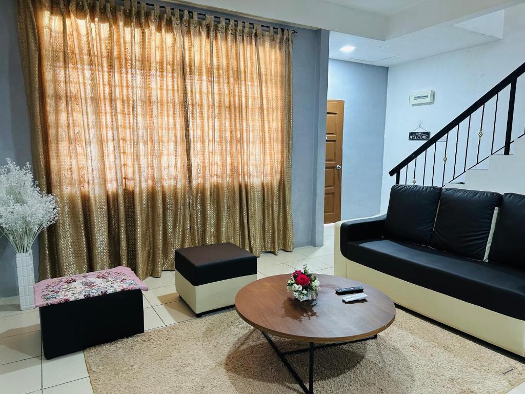 斗湖Macagawa Homestay的客厅配有沙发和桌子