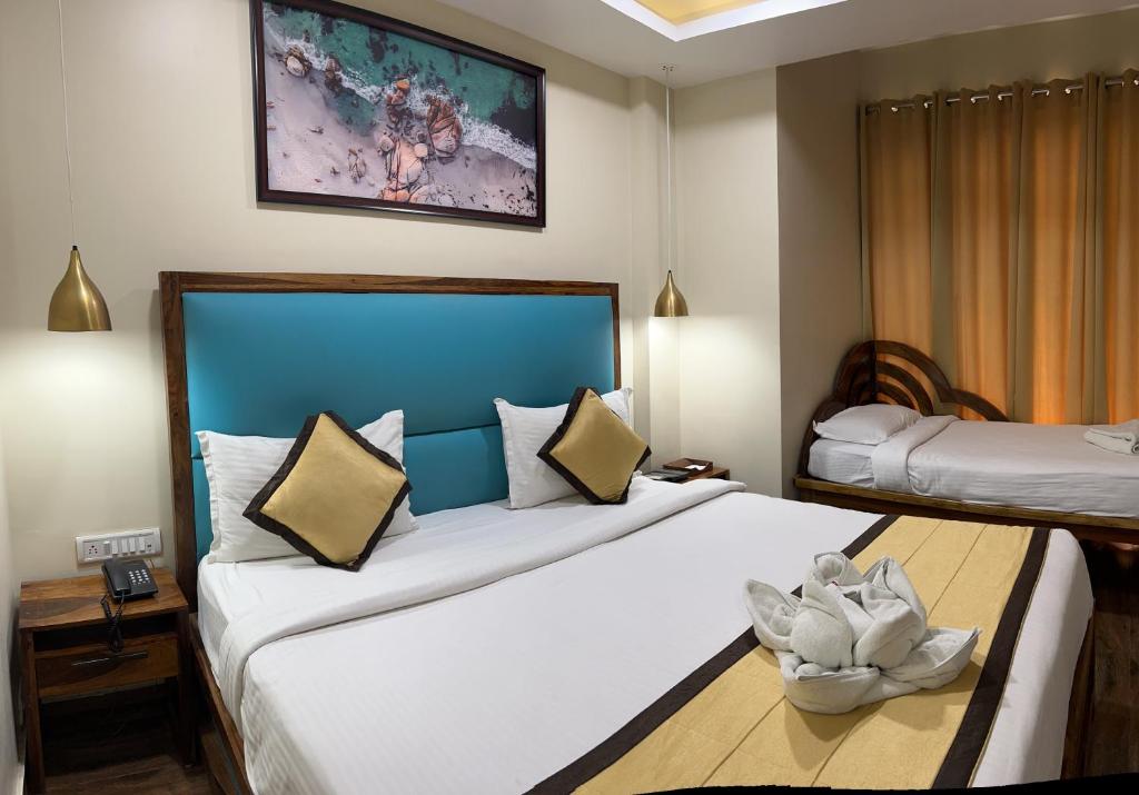 布莱尔港SeaScape Port Blair的酒店客房设有两张床,墙上挂有绘画作品