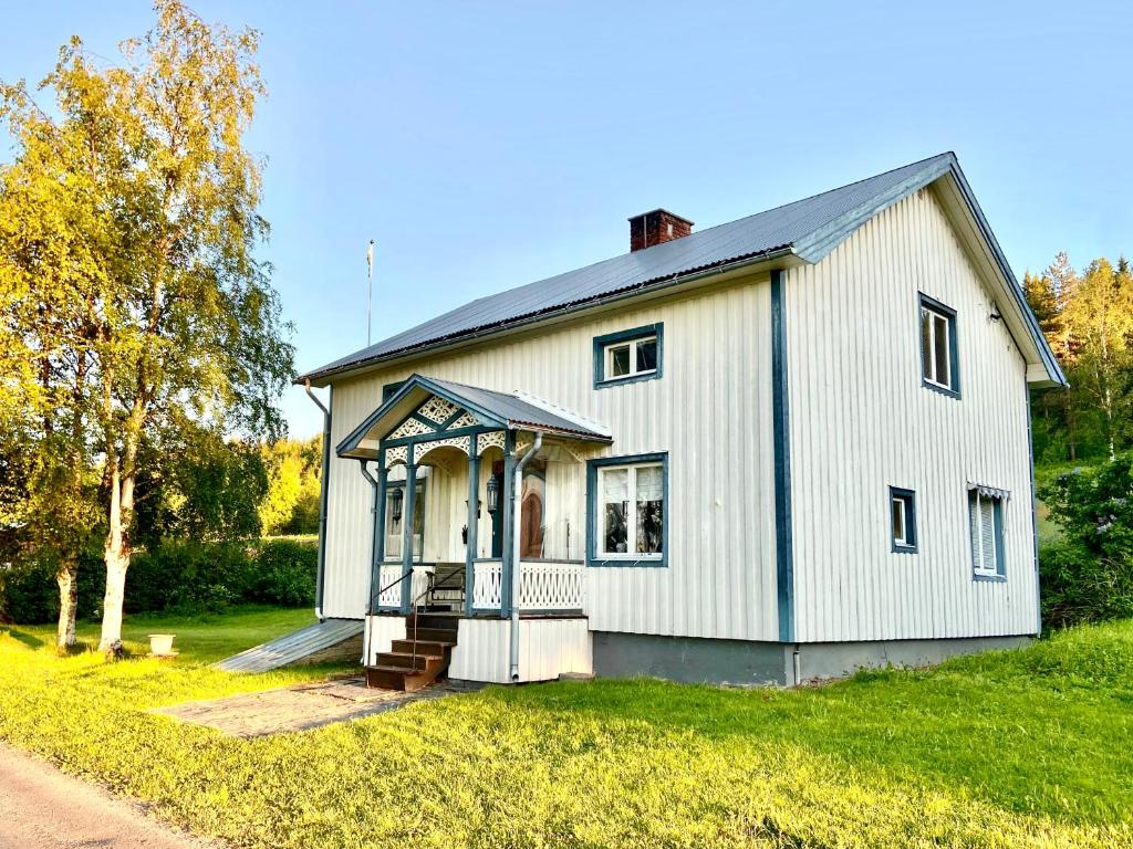斯特伦松德Vildmarksgård Lillviken的草坪上带门廊的白色房屋