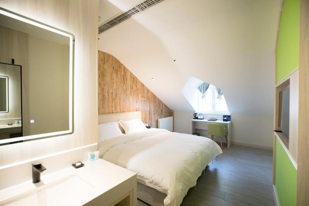 北京北京世家精品酒店 的一间卧室配有床、水槽和镜子