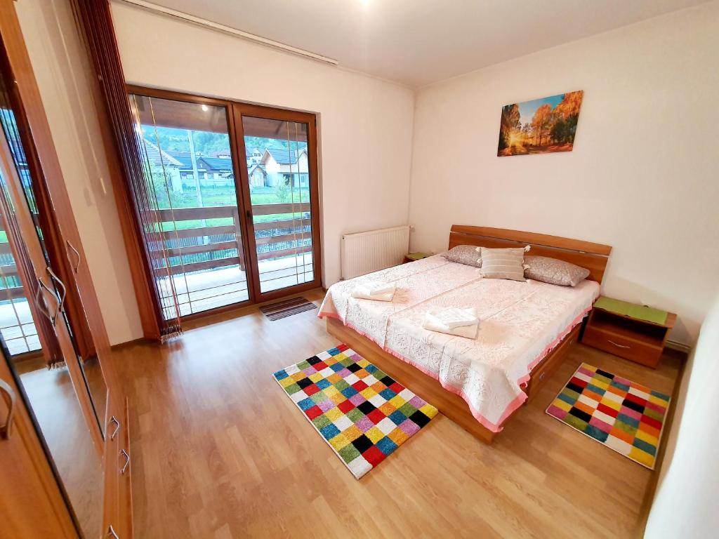 鲁克尔Pensiunea Geta的一间卧室配有一张色彩缤纷的地毯。