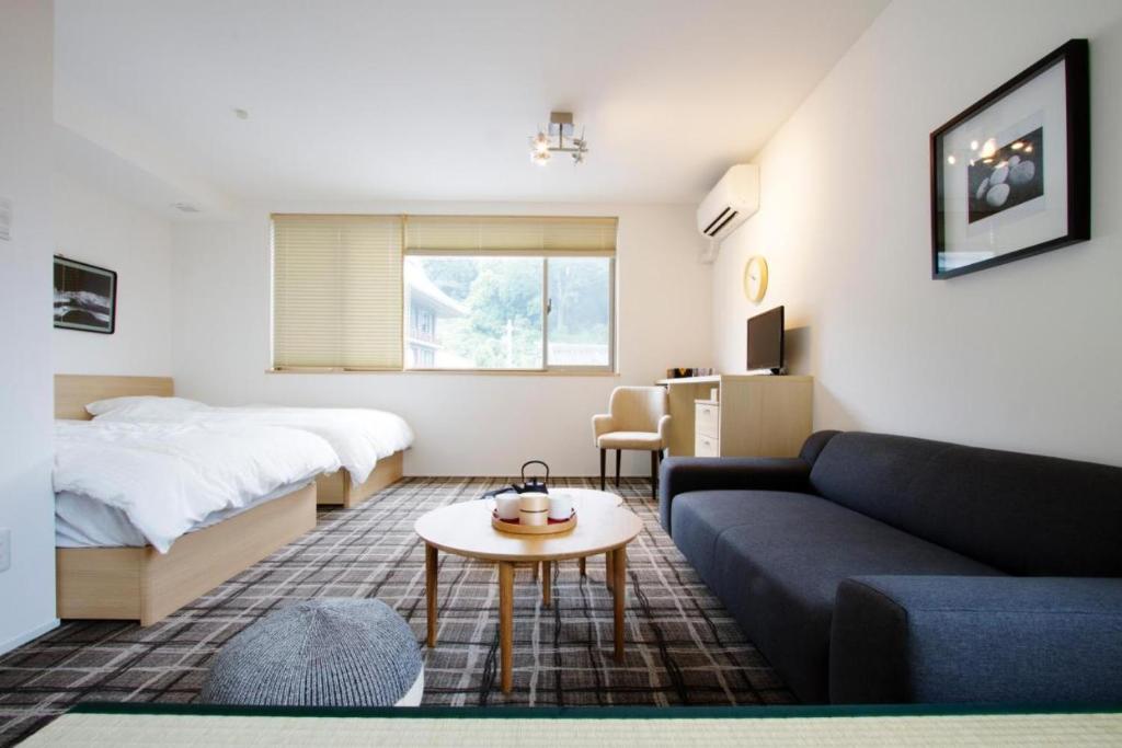 京都スイートステイ京都 Suite Stay Kyoto的客厅配有床和沙发
