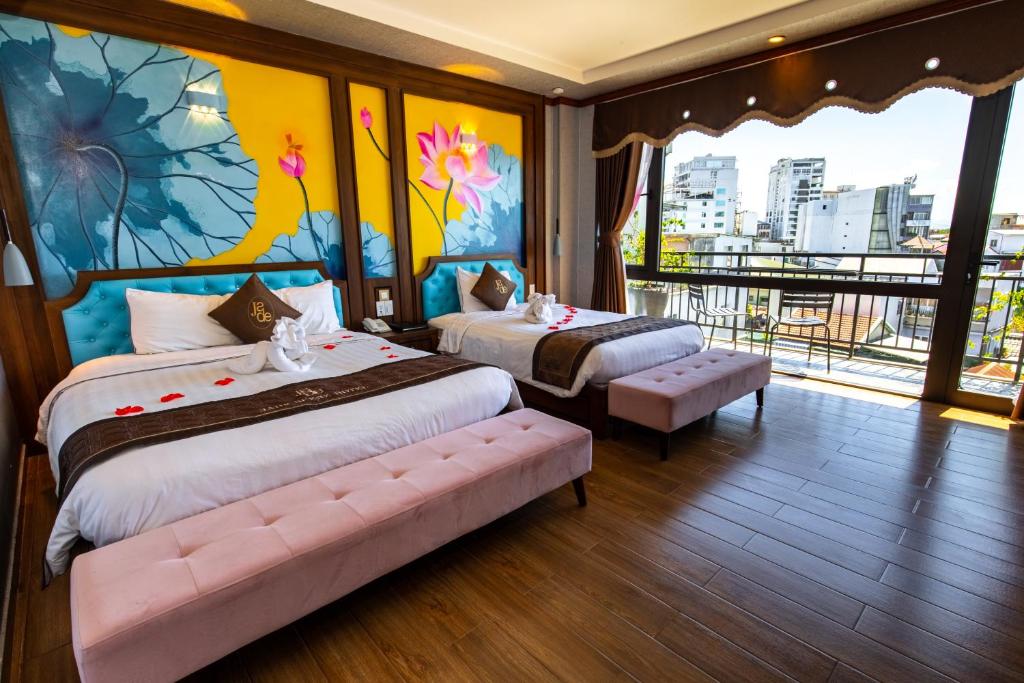 顺化Jade Scene Hotel的一间配备有两张床的卧室,享有城市美景。