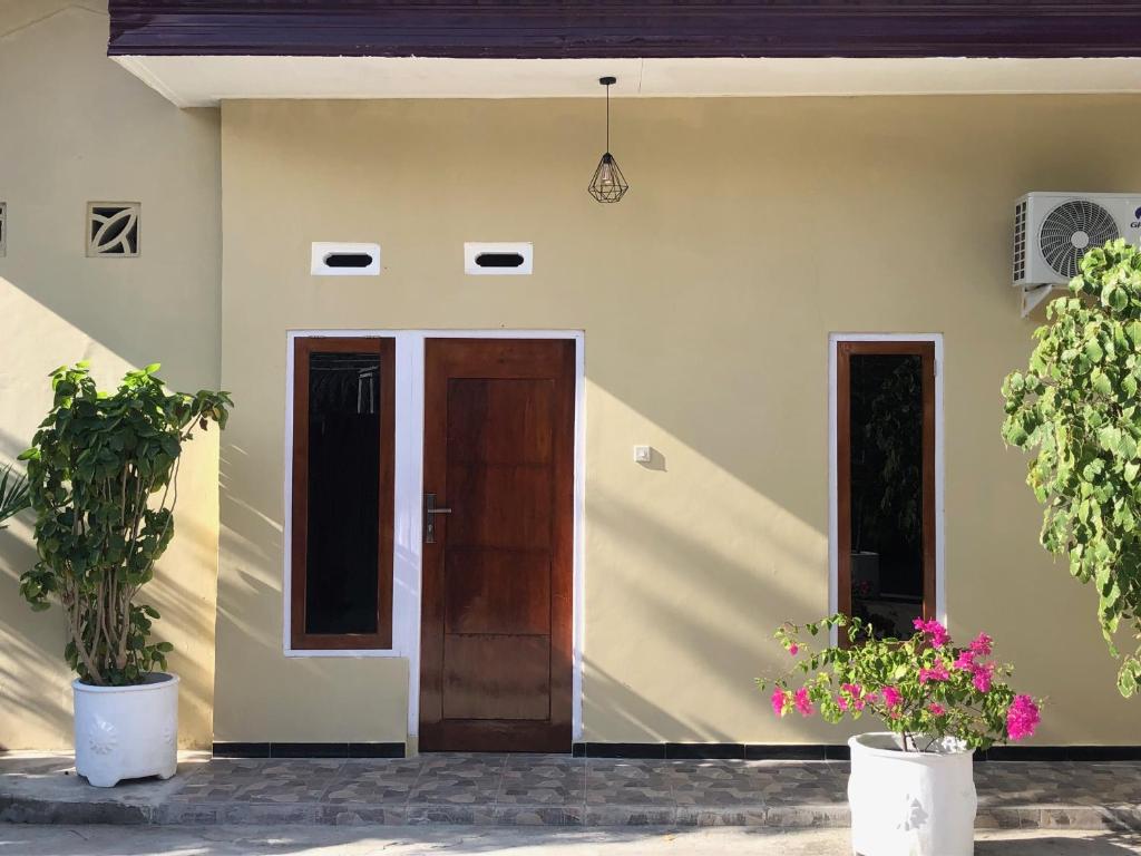 NdanguLOPE HOMESTAY的两扇门和两盆植物的房子