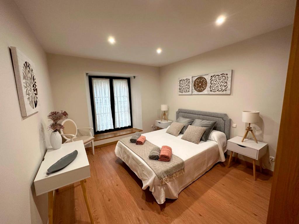 巴利亚多利德Apartamento Lujo centro histórico的一间卧室配有一张大床和两张桌子
