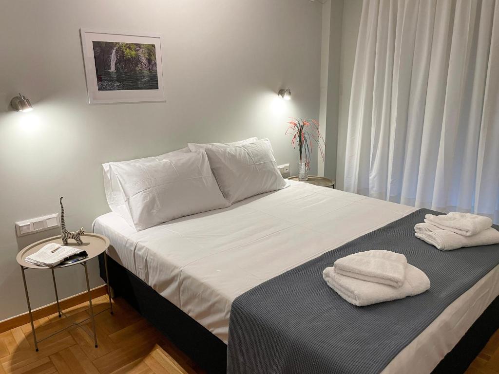 雅典Iris的一间卧室配有一张床,上面有两条毛巾