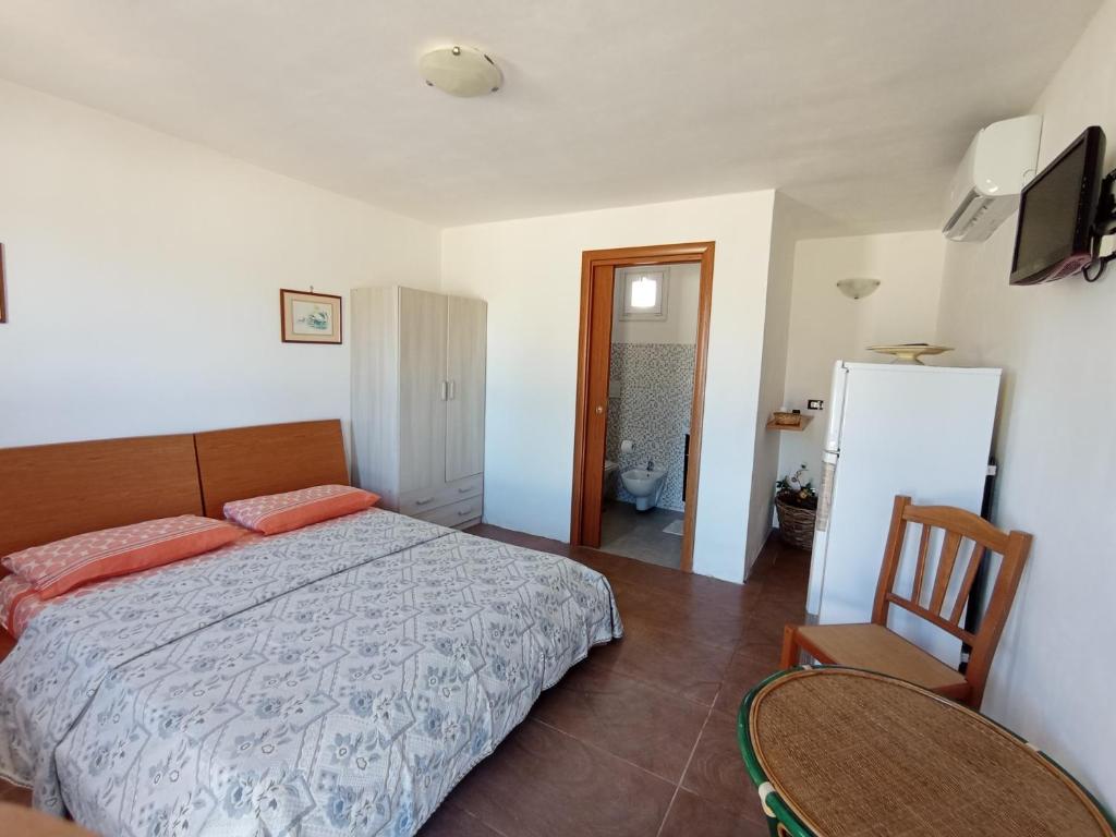 切萨雷奥港Stanze Agli Ulivi的一间卧室配有一张床、一把椅子和一台冰箱