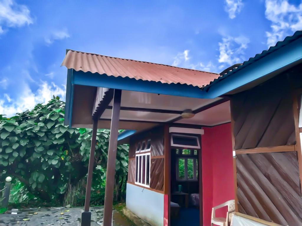 拉瓦格拉The Himalayan Resort的一间拥有红色和蓝色外墙的小房子