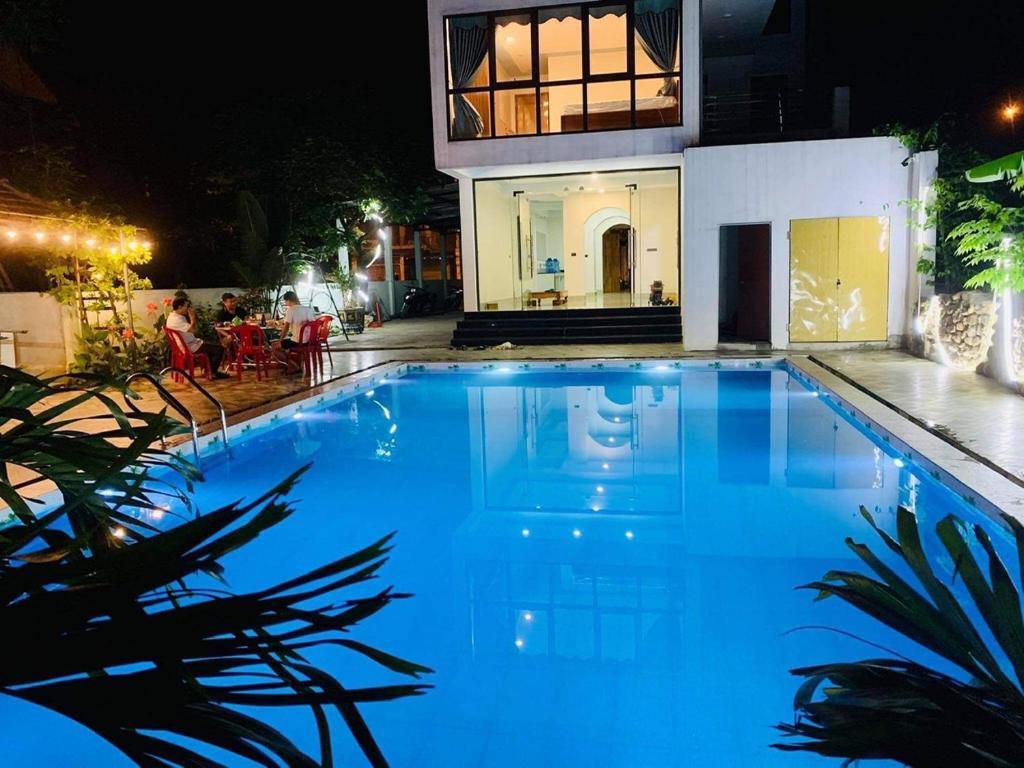 峰牙Phong Nha Moonlight Villas的一座大蓝色游泳池,位于房子前
