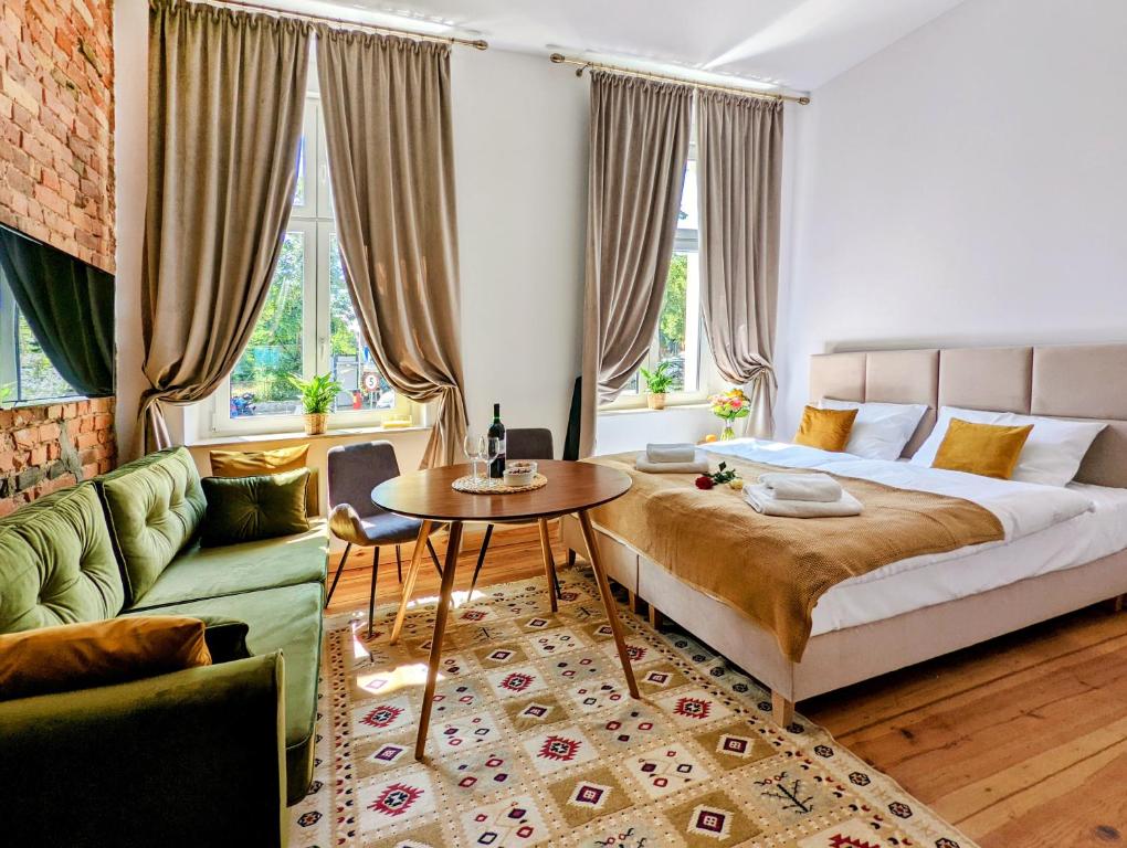 波兹南Apartamenty Strzelecka 34的一间卧室配有一张床、一张桌子和一张沙发