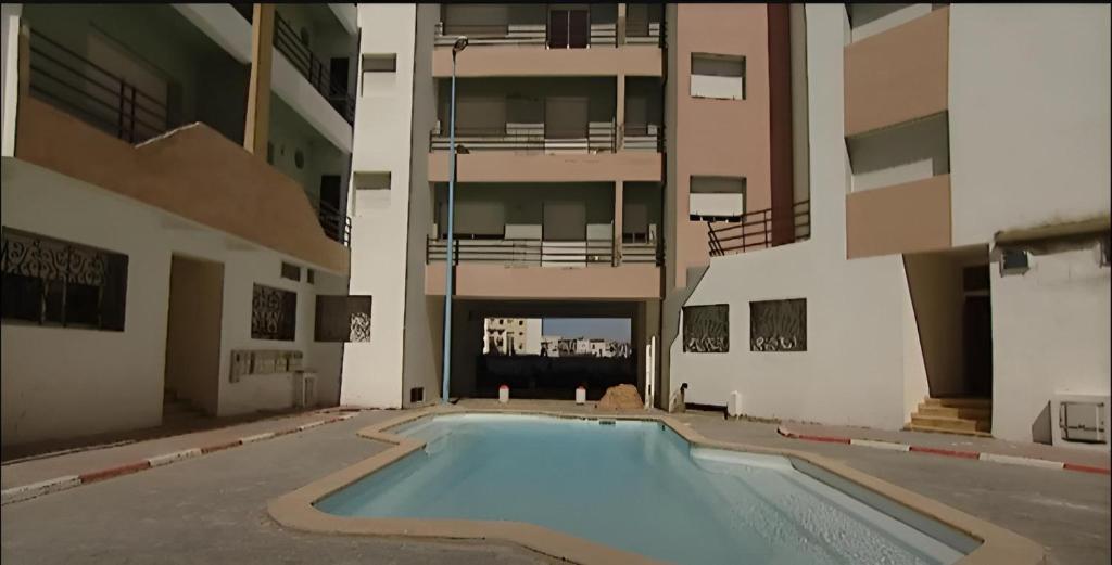 杰迪代Découvrez la magie d'El Jadida depuis notre appartement de charme的一座大楼中央的空游泳池