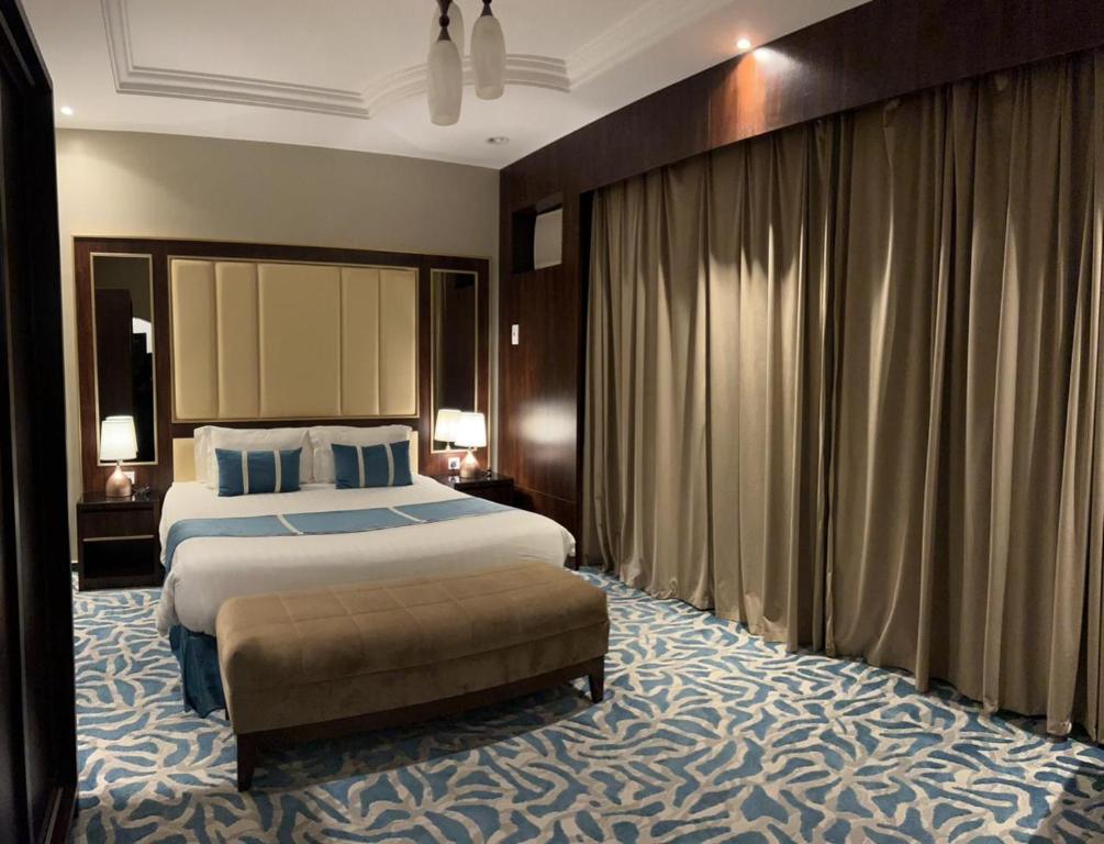 Sūq al Aḩadفندق وايت هافن的酒店客房设有一张大床和一张沙发。