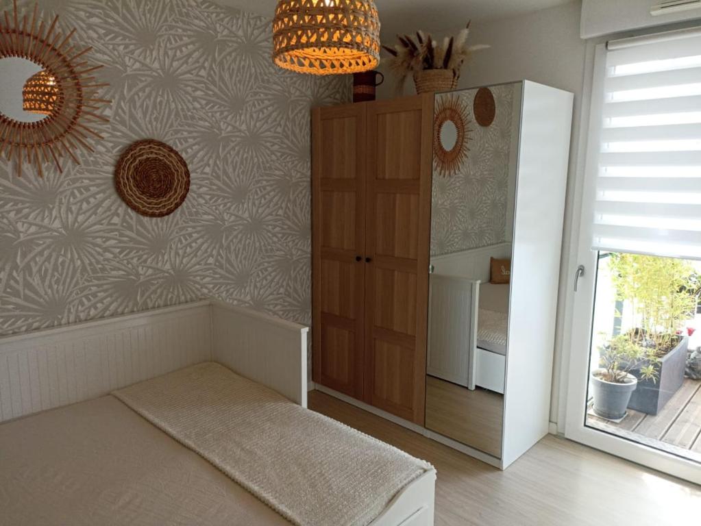斯特拉斯堡Chambre nature chez l'habitant的客房设有床、橱柜和窗户。