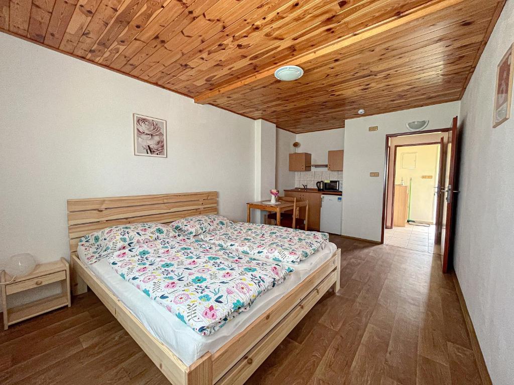 KuchařovicePenzion Hevera的一间卧室设有一张床和木制天花板
