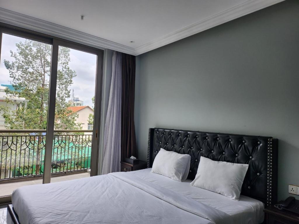 土龙木市Feliz Hotel Binh Duong的一间卧室设有一张床和一个大窗户
