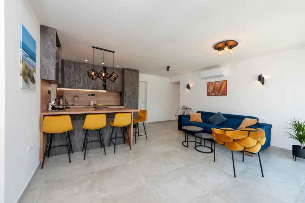 卡斯塔夫Apartman Noa的厨房以及带蓝色沙发的客厅。
