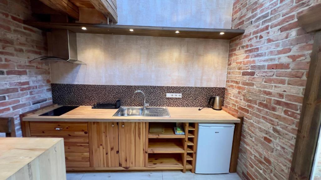UlmaleKapteinis Āķis apartamenti的厨房设有水槽和砖墙