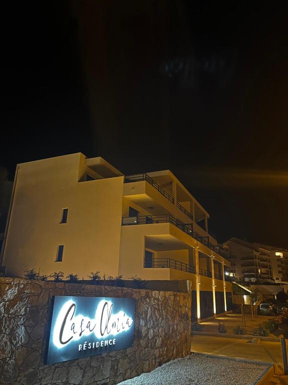 卡尔维Casa Olmia Résidence的一座建筑,在晚上前有标志