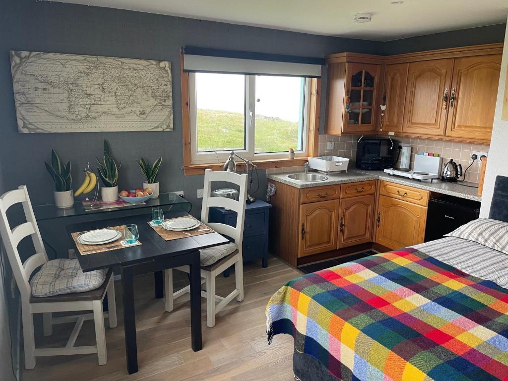 ClachanMusic of the Sea- Isle of South Uist, HS8 5RF的一个带桌子和床的小厨房
