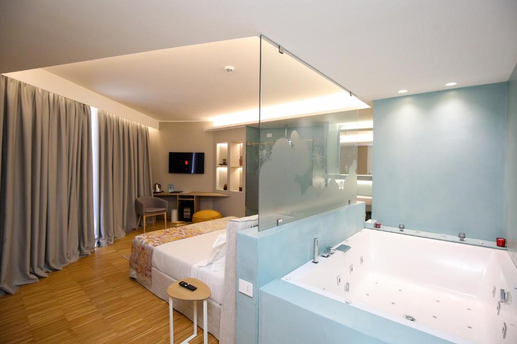 伏罗拉Priam Hotel Luxury Resort的酒店客房配有一张床和浴缸。