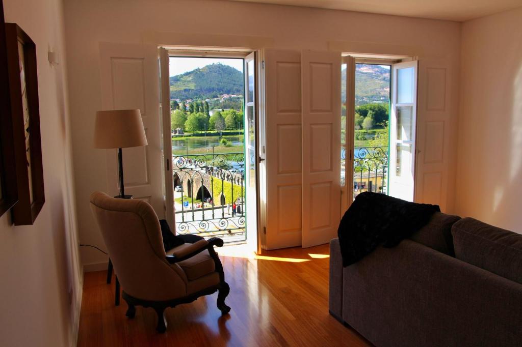 蓬德利马Alma Da Vila的带沙发、椅子和窗户的客厅