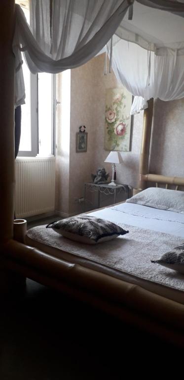 佩里格Côté jardin的一间卧室配有一张带天蓬的床