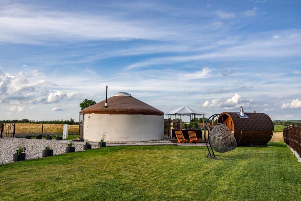 GrabinekJurtowe Wzgórze Glamping的草地上带屋顶的大型凉亭