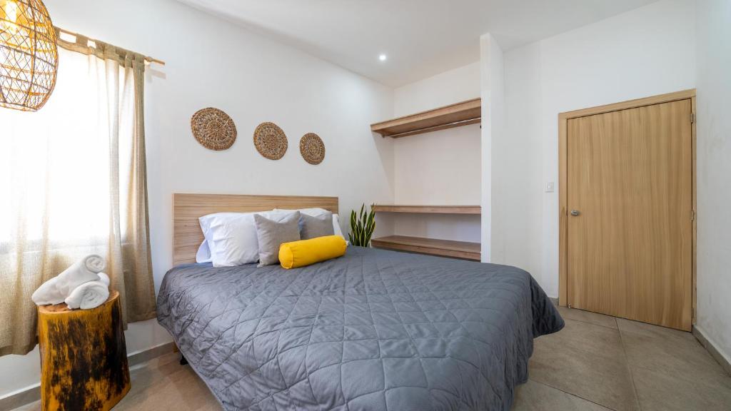 拉利伯塔德Coco Surf Tropical Village的一间卧室配有一张黄色枕头的床
