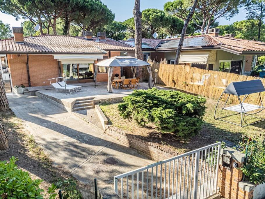 利尼亚诺萨比亚多罗PINETA HOUSE LIGNANO [Free Parking-Beach-Garden]的房屋设有带桌子和遮阳伞的庭院