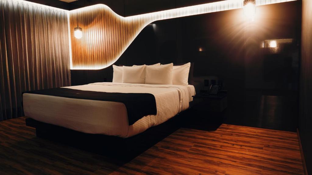 克雷塔罗Hotel Yoru的一间卧室配有一张大床和灯光