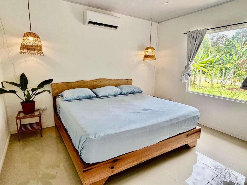 卡维塔Casa Martin Cahuita Charming Spanish Home的一间卧室设有一张床和一个窗口