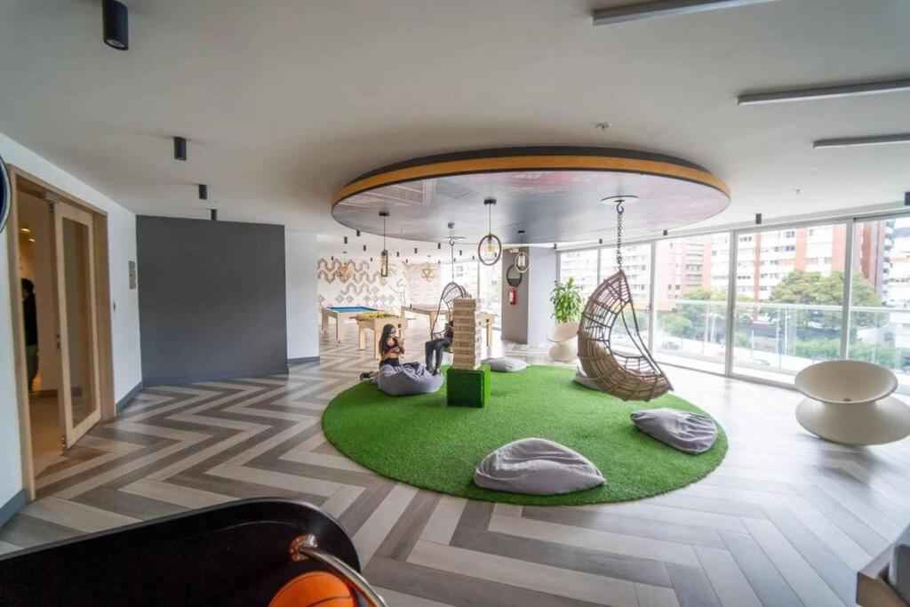 基多Suite Martina 2 Personas Quito的客厅配有绿色地毯和秋千