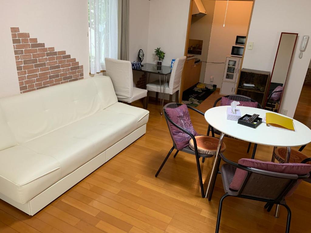 札幌Sejour Toyohirakoen的客厅配有白色的沙发和桌子