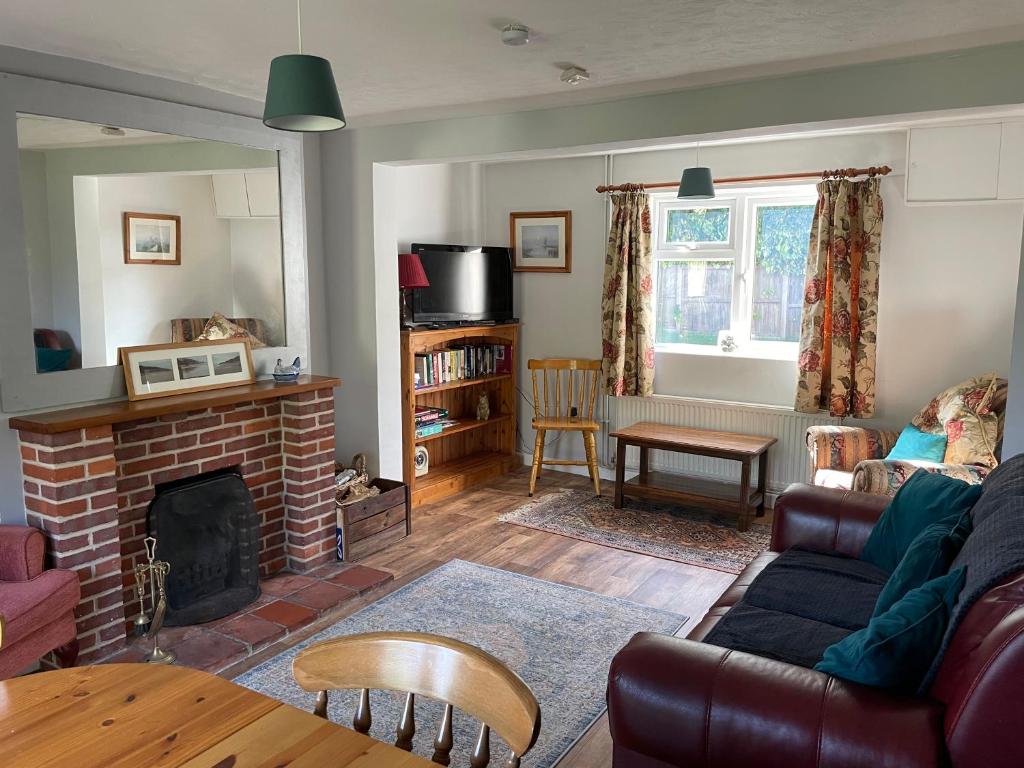 SwafieldBetty's Cottage - Traditional Norfolk Farm Cottage的带沙发和壁炉的客厅