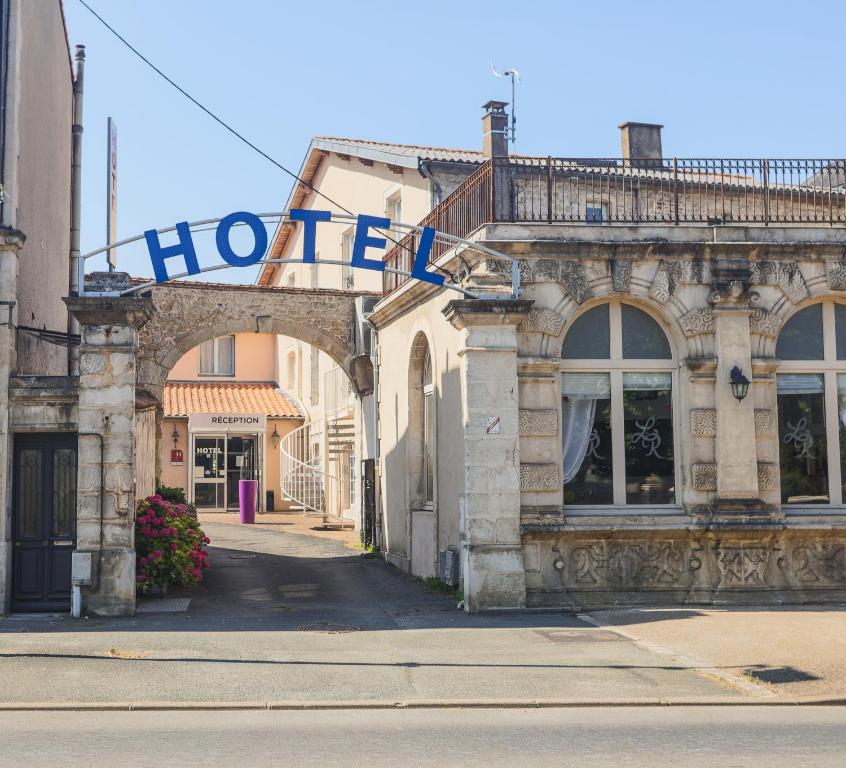 圣迈克桑莱科勒Hôtel Le Cheval Blanc的街道上带有酒店标志的古老建筑