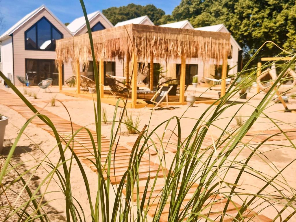 梅尔诺Lulu Holiday Resort的海滩上带稻草屋顶的房子