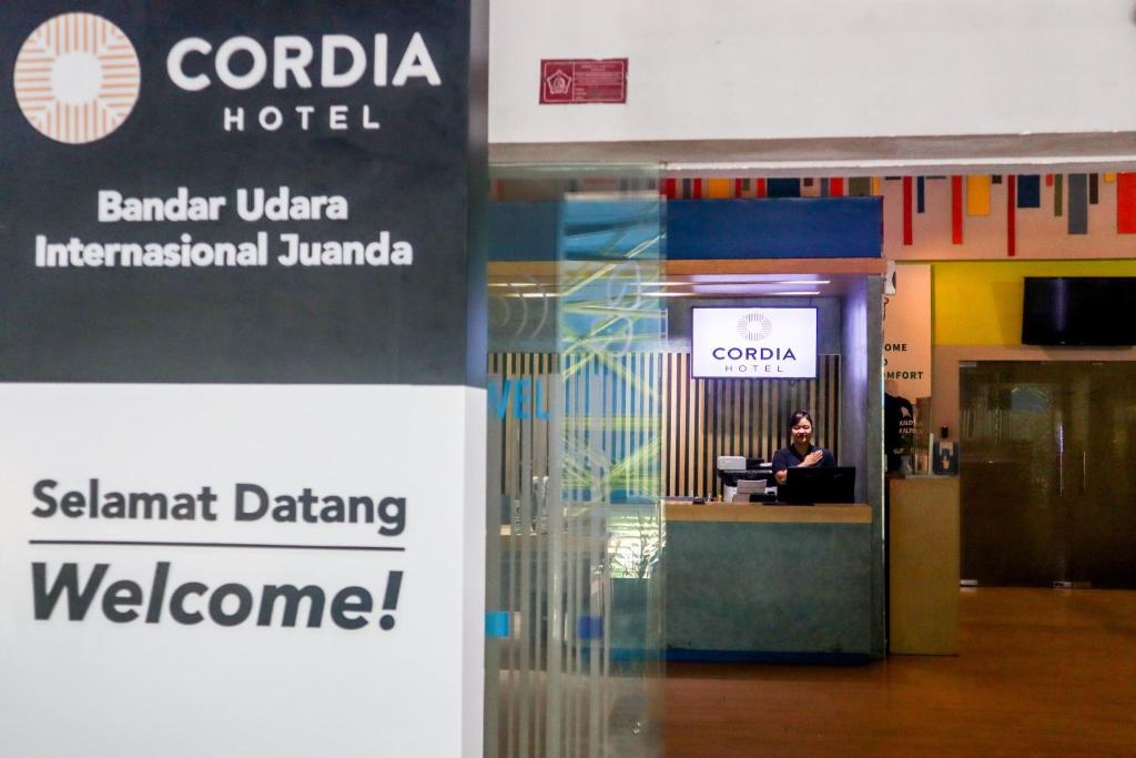 诗都阿佐Cordia Hotel Surabaya Airport - Hotel Dalam Bandara - Formerly Ibis Budget Surabaya Airport的坐在机场桌子上的女人