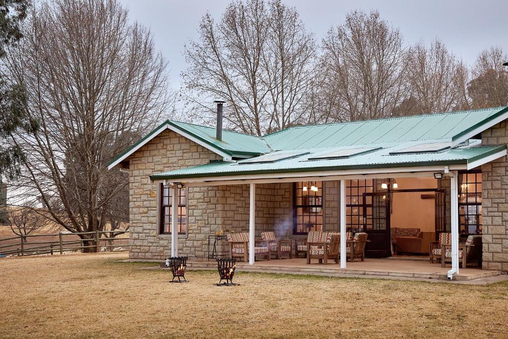 安德伯格Bergview Farm Cottages的一座带绿色屋顶的小砖屋