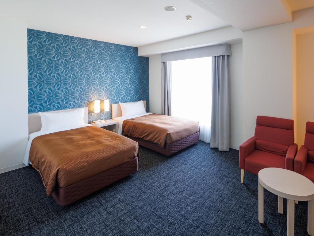 常滑市临空J酒店的酒店客房,配有两张床和椅子