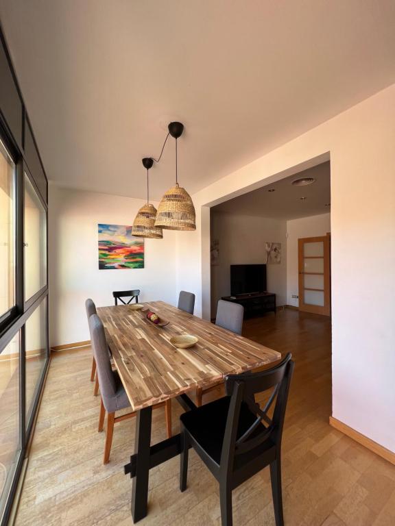 略夫雷加特河畔圣费柳CASA NEUS, casa junto a Barcelona的一间带木桌和椅子的用餐室
